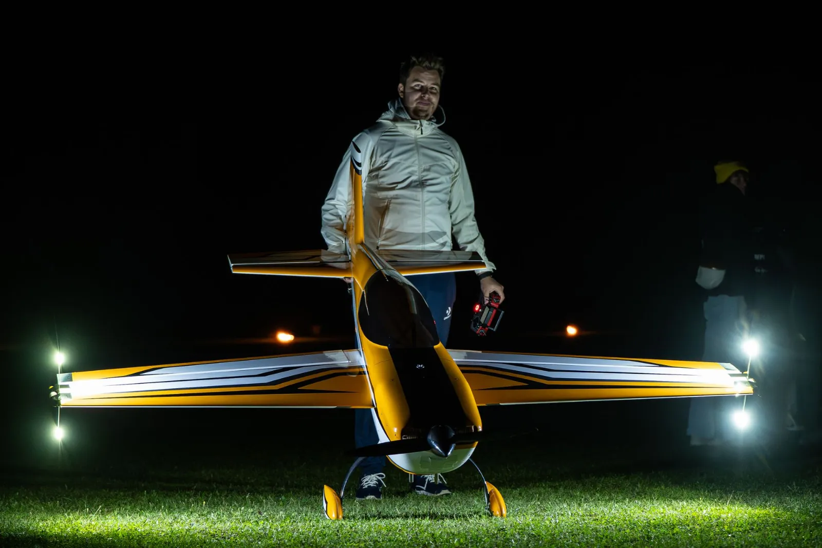 Pilot hält gelbes Modell mit beleuchteten Flügelenden