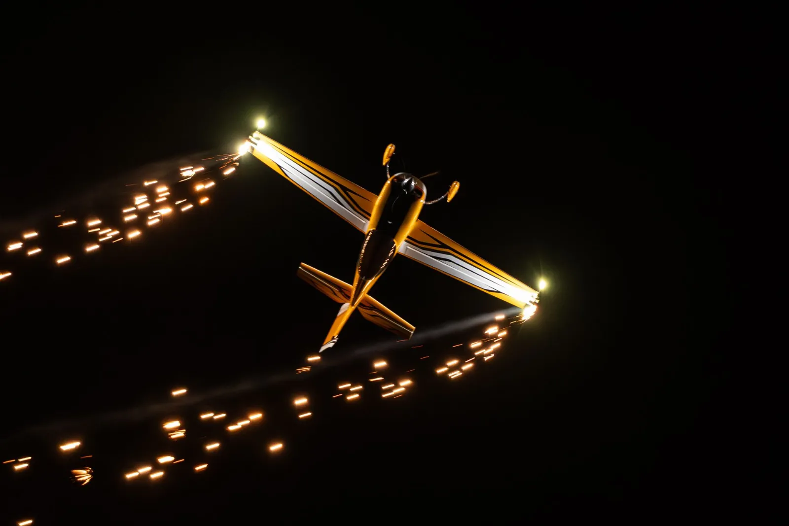 Nachtflug mit Lichtspuren und Funken